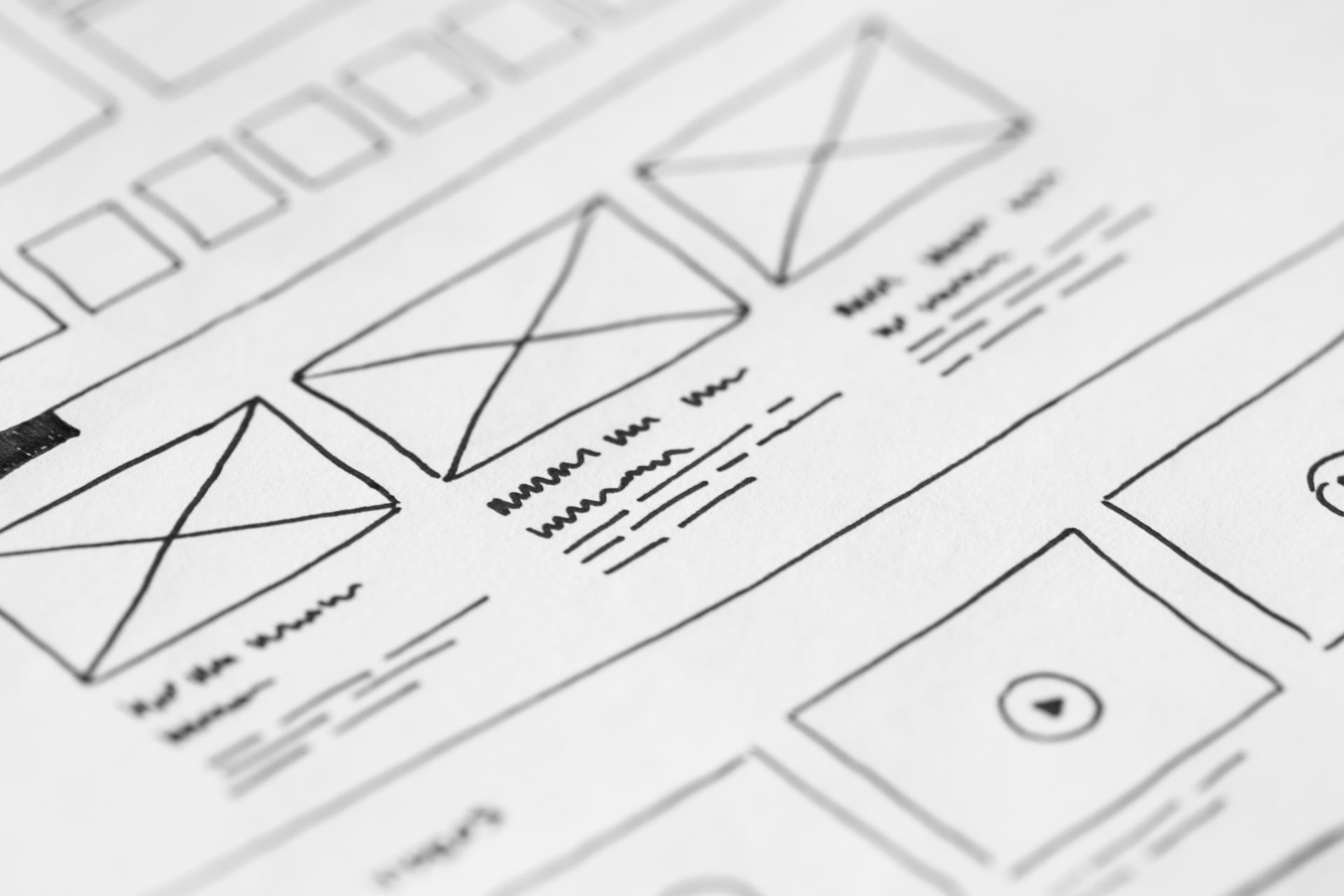 A photo of website wireframes hand drawn on a piece of paper.